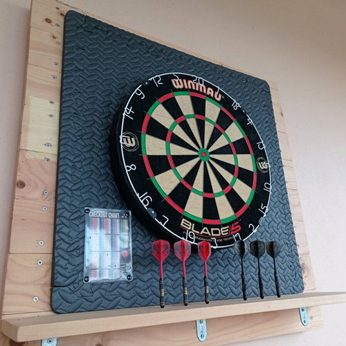 Winmau Blade 5 dartboard used with darts and wooden backing