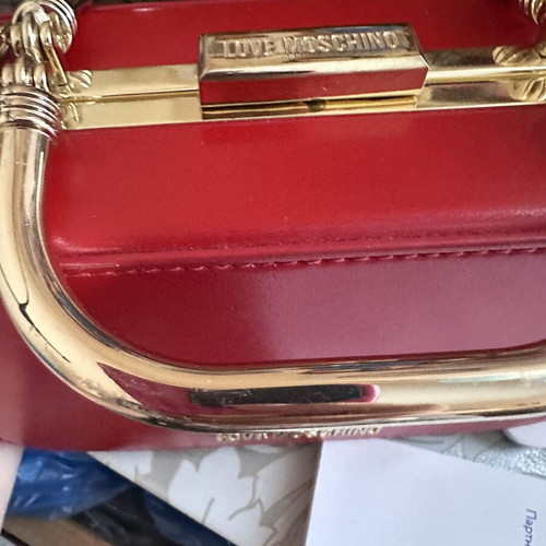 Love Moschino red shoulder bag like new with gold metal clasp and embossed detail