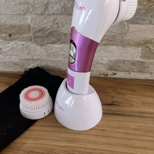 Facial cleansing device used with two heads and stand