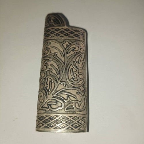 Vintage silver lighter case used with carved floral patterns