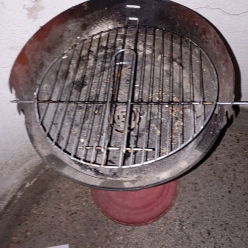 Portable vintage charcoal barbecue with red central leg, used