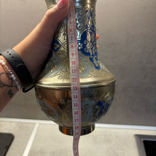 Vintage metal vase used with embossed designs and blue details