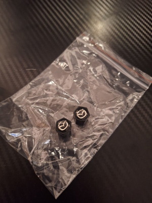 Mazda valve caps like new, black with silver detail, set of 2