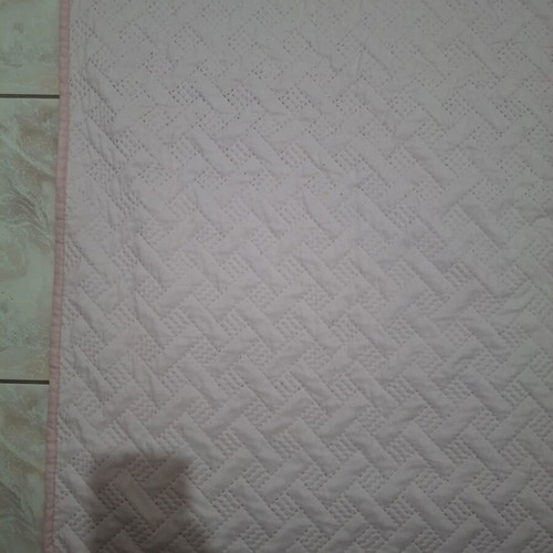Quilted bed cover in soft pink