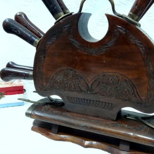 Wooden carved stand with used set of knives and forks