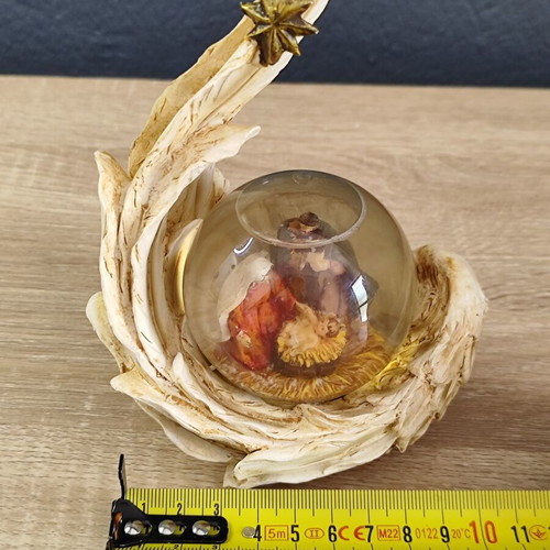 Christmas decorative snow globe featuring the Nativity and a base shaped like an angel's wing
