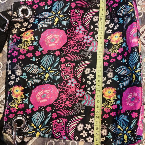 Crossbody fabric bag with colorful floral pattern, black background