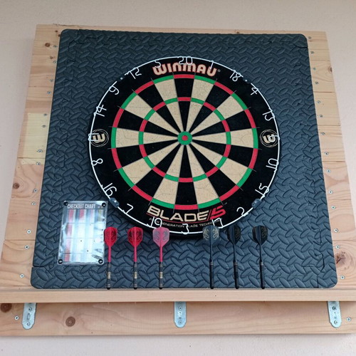 Winmau Blade 5 dartboard used with darts and wooden backing