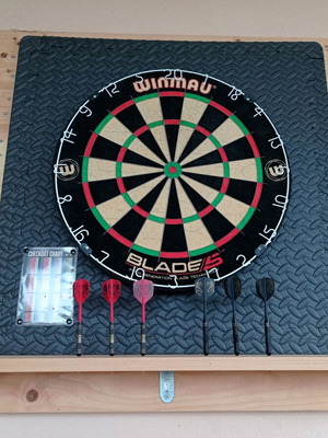 Winmau Blade 5 dartboard used with darts and wooden backing
