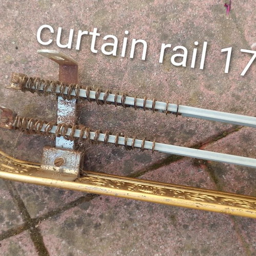 Metallic vintage curtain rail with brass coloured details used
