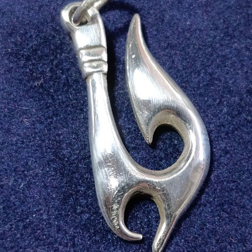 Silver Maori-inspired pendant in traditional hei matau style