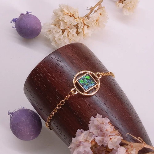 Bracelet with green iridescent stone, gold-colored steel