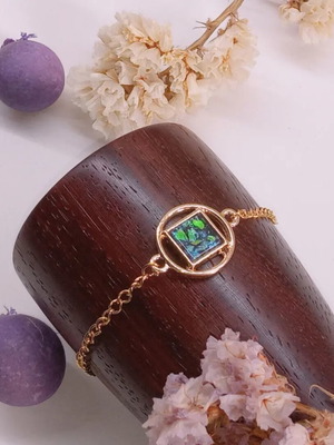 Bracelet with green iridescent stone, gold-colored steel