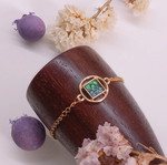 Bracelet with green iridescent stone, gold-colored steel