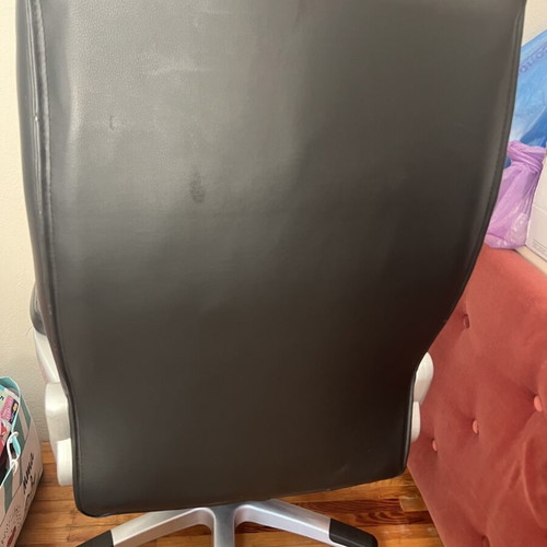 Office chair with black faux leather upholstery and button-tufted back