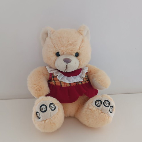 Plush teddy bear with dress and numbers on paws
