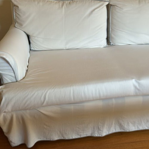 Two-seater sofa like new with ivory cover and grey-blue stitching