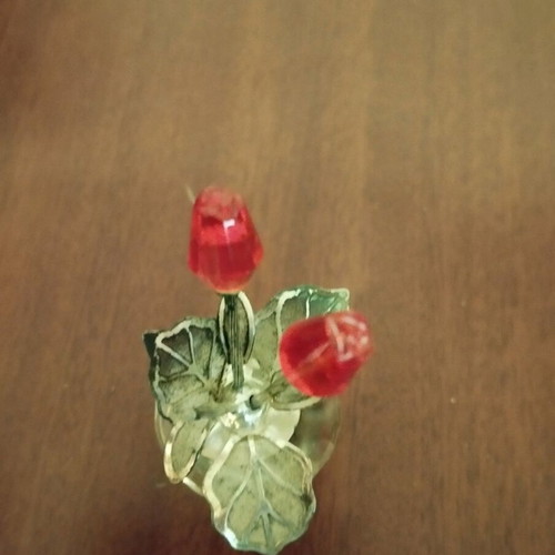 Glass bottle stopper used with decorative flowers and metal leaves