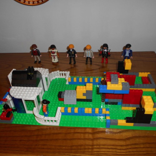 Building toy with Lego bricks and 6 Play Mobil figures used