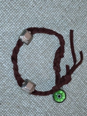 Evil eye bracelet used with brown cord and silver decorations