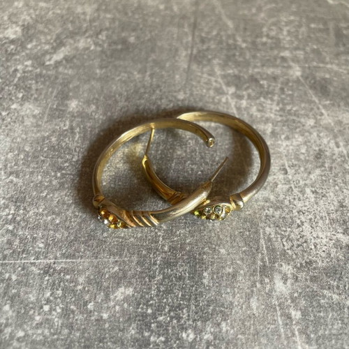 Gold-colored earrings used with small diamonds, some missing