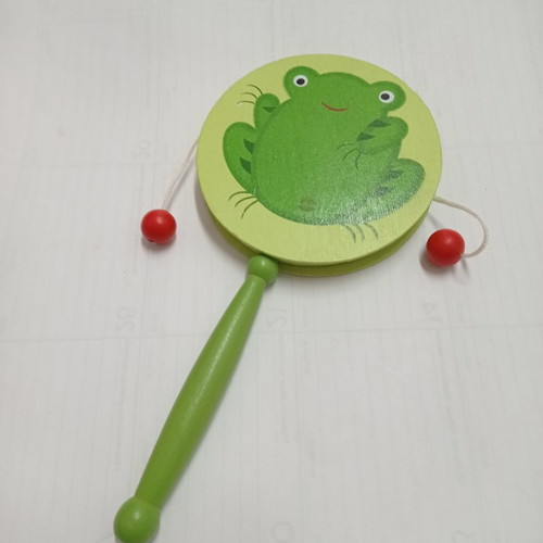 Wooden musical instrument drum with green frog used