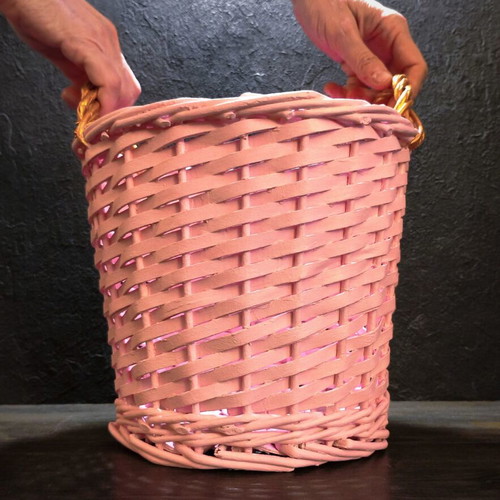 Decorative pink rattan basket with gold handles, handmade