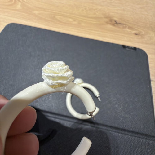 Pair of off-white matte resin hoop earrings with fabric floral accents