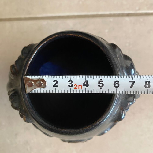 Black ceramic vase with ram’s head decoration