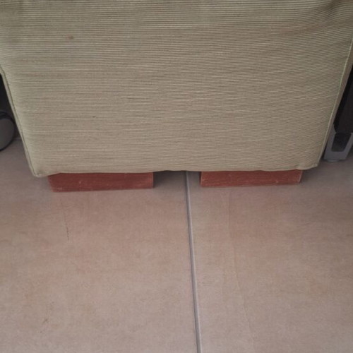 Light green fabric-covered stool with wooden legs