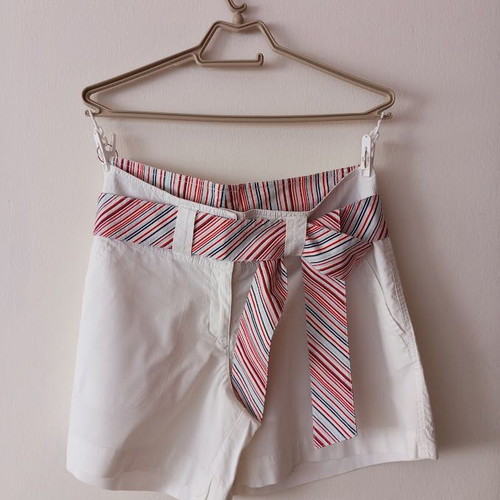 Red sleeveless blouse like new with white shorts and striped belt