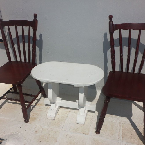 Wooden set with oval white table and 2 traditional dark chairs used for outdoor