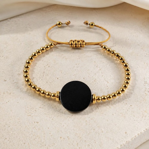 Bracelet with gold beads and black wooden adjustable element
