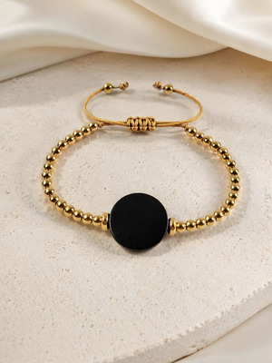 Bracelet with gold beads and black wooden adjustable element