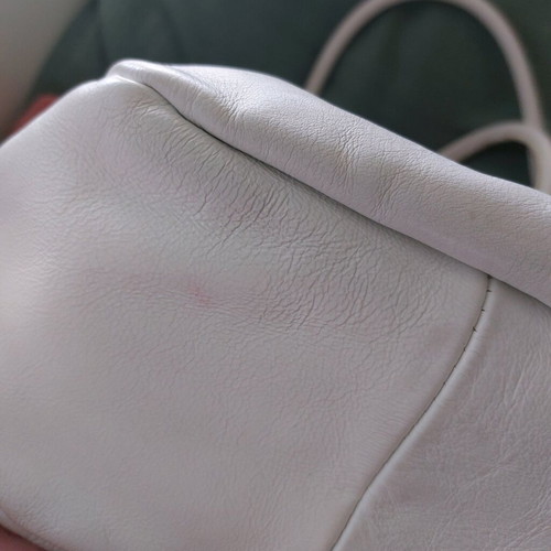 White bucket handbag used with decorative buttons