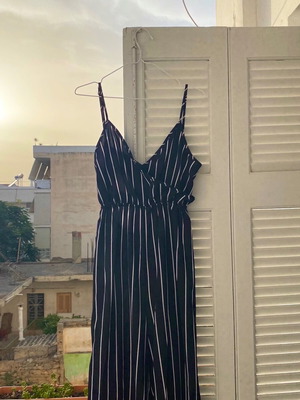 μαύρη ολόσωμη φόρμα με λευκες ρίγες και δέσιμο στη πλατη με ανοιχτή παλτη