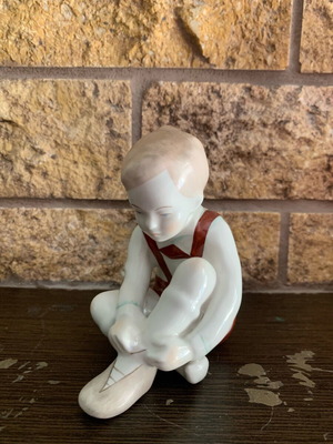 Porcelain figurine "The boy is putting on his shoes" like new