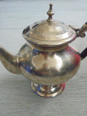 Old metal teapot with elegant handle, used