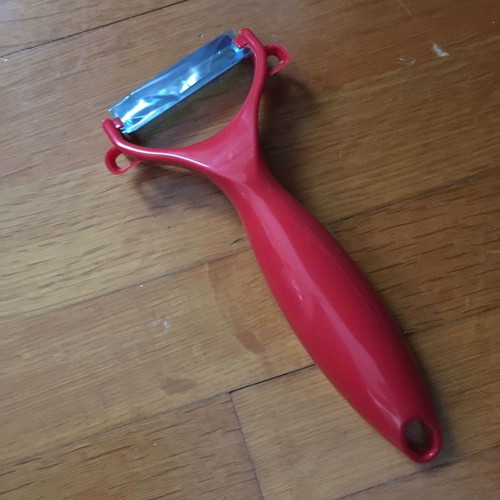 Red peeler new with thick handle made of durable plastic