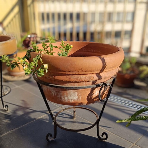 Large terracotta pot with metal stand and clay wedges, used