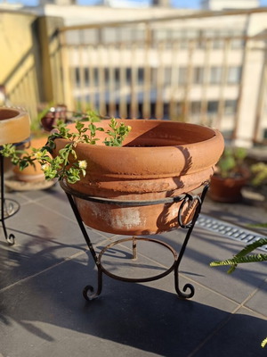 Large terracotta pot with metal stand and clay wedges, used