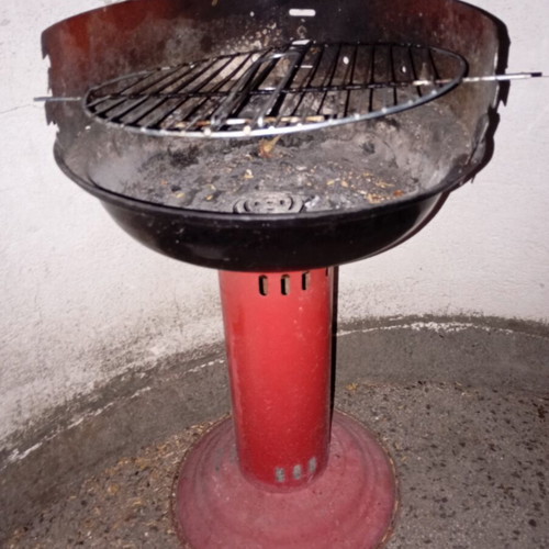 Portable vintage charcoal barbecue with red central leg, used