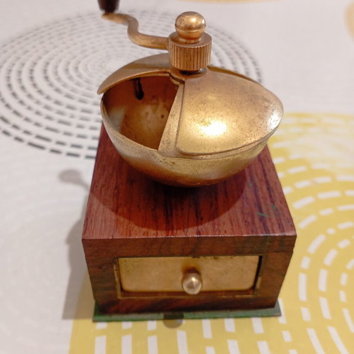 Vintage miniature manual coffee grinder with wooden body and brass hopper