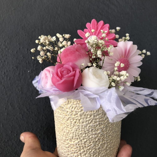 Flower arrangement with scented candles in plaster vase