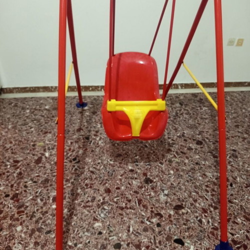 Child swing with metal frame and plastic seat, used with plastic wear
