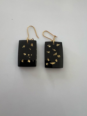 Earrings hanging from liquid glass like new, black and gold