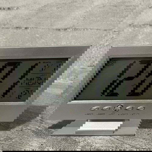 Digital table clock used with alarm and thermometer