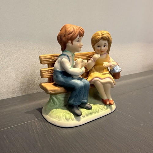 Porcelain decoration with two children on bench like new