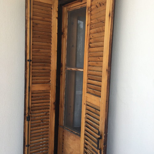 Village-style balcony doors and wooden window used with screen