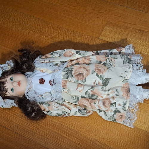 Porcelain collectible doll with brown curly hair and vintage dress, new